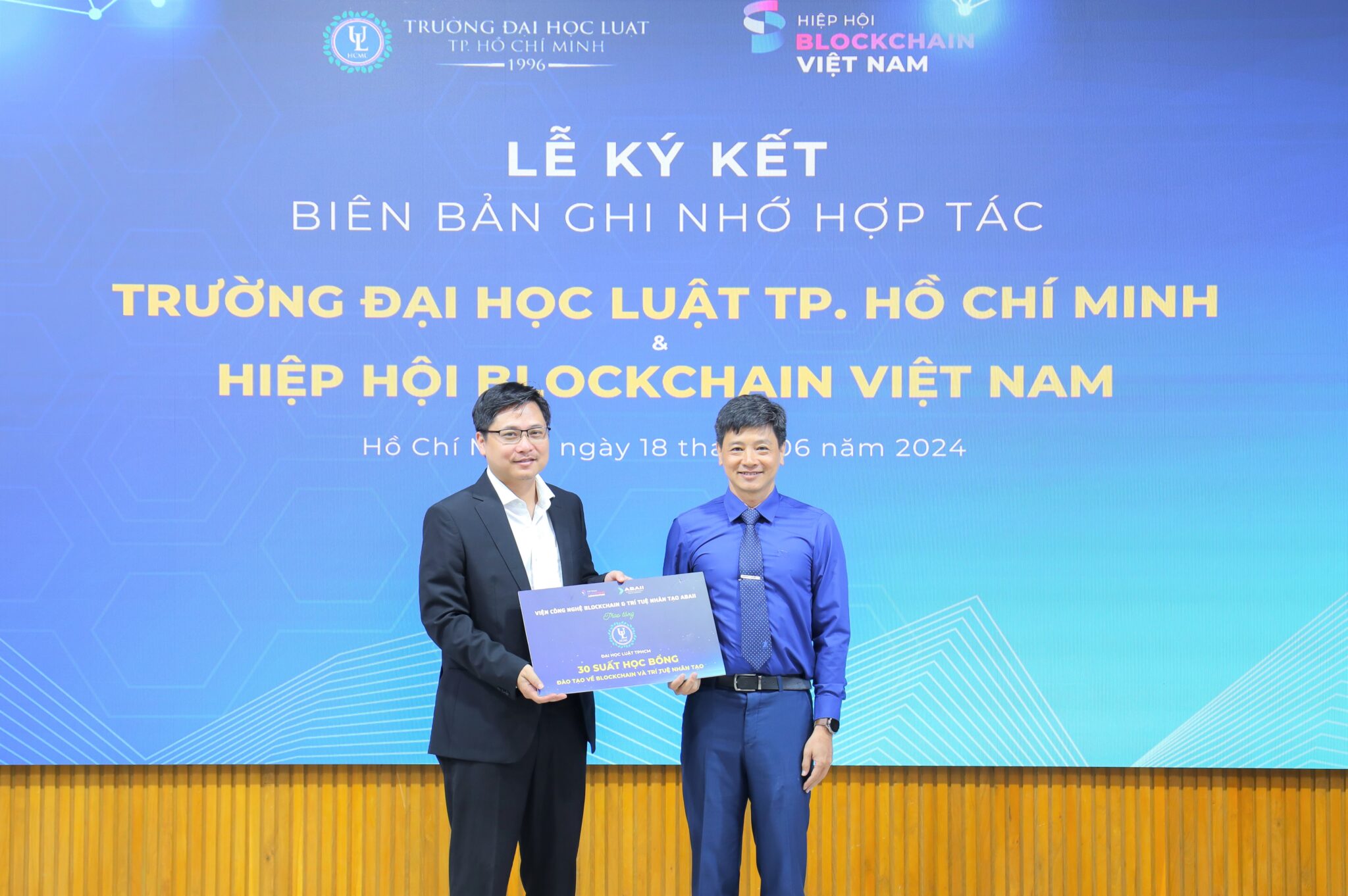 Ông Trần Việt Dũng, Phó Hiệu trưởng Đại học Luật TP.HCM, nhận học bổng từ ông Đào Trung Thành, Viện phó Viện ABAII