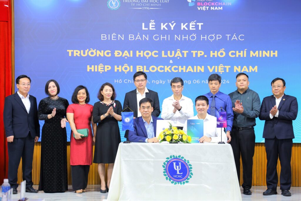 Mr. Le Truong Son, Rector of Ho Chi Minh City University of Law (in blue), signed the Memorandum of Understanding with Mr. Phan Duc Trung, representing the Vietnam Blockchain Association.